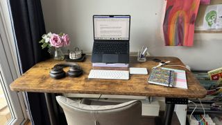 A brown wooden Maidesite TH2 Pro Plus desk in a bright home office